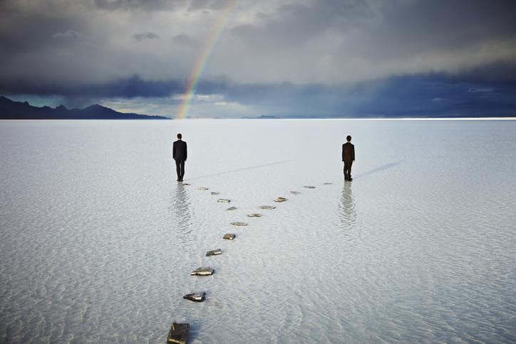 Two men on a forked pathway with rainbow