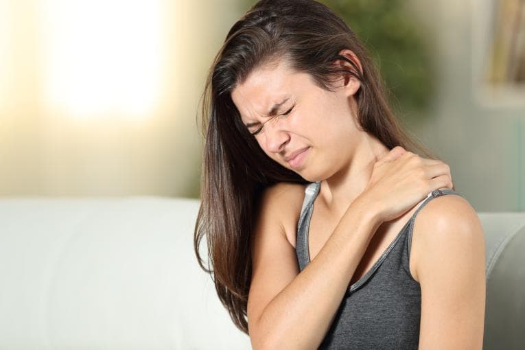 Girl holding her shoulder in chronic pain