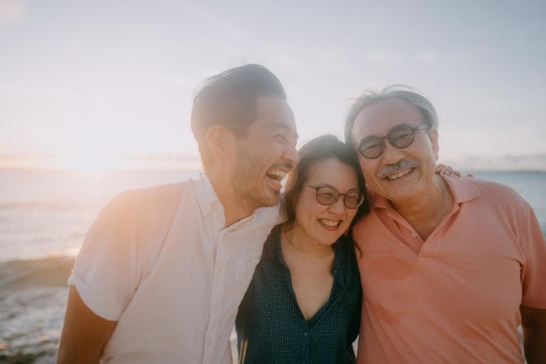 Happy Japanese family laughing on a beach