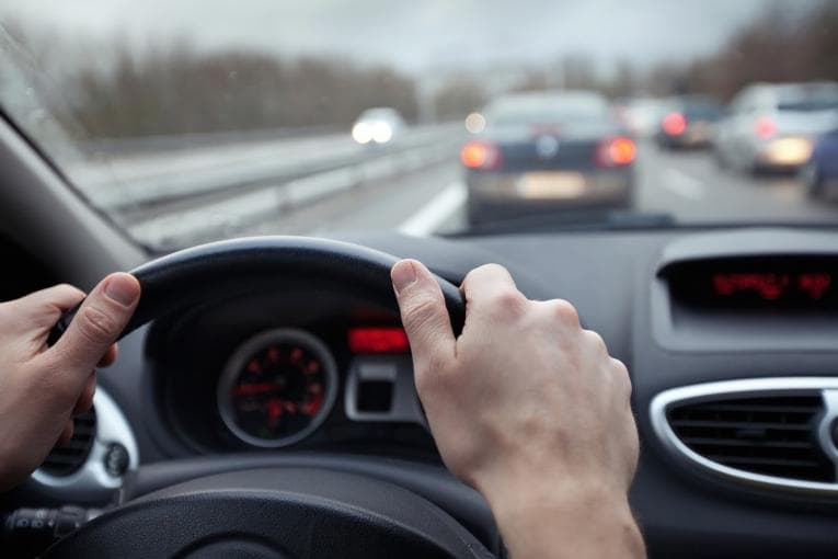 Hands on steering wheel in a car