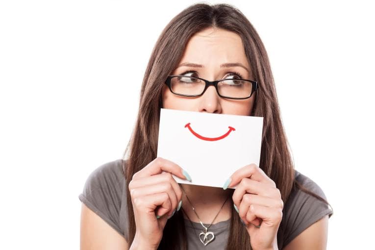 Person holding up card with smiley drawn