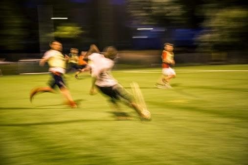 Blurry image of three people playing football