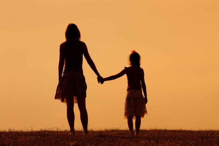 Silhouette of mother and daughter holding hands