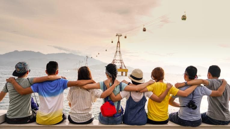 Teenagers close together looking out to sea 