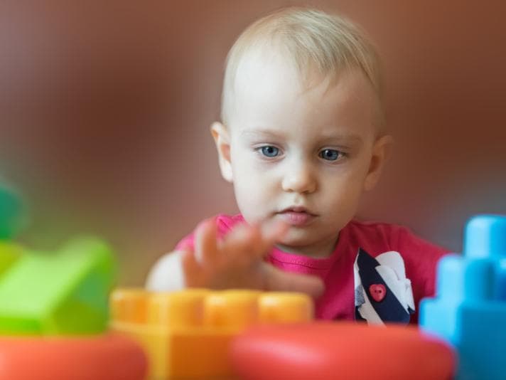 Toddler playing with plastic blocks