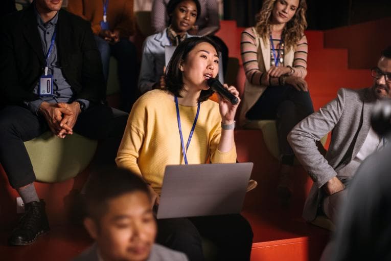 Woman asking a question at a conference