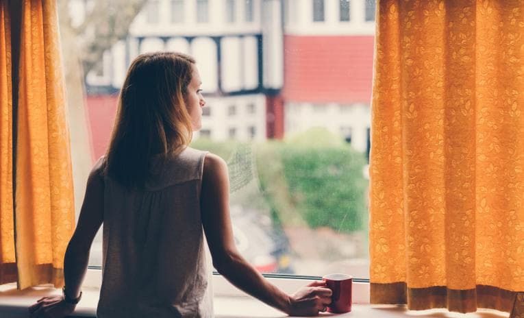 Lonely woman looking out of a window