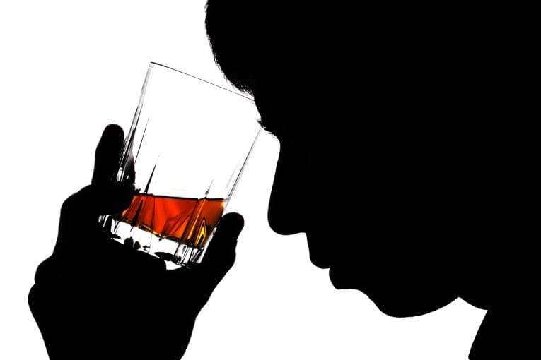 Blacked out silhouette of man drinking whiskey