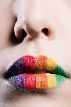 Person's lips painted in many different colours