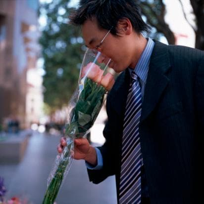 Person smelling a bouquet of roses