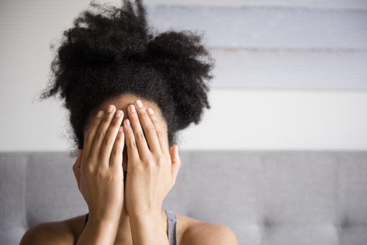 Woman hides face with hands