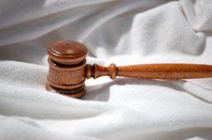 A gavel lying on white cloth