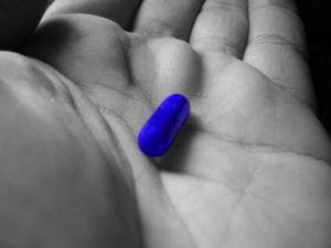 Palm holding blue pill of choice