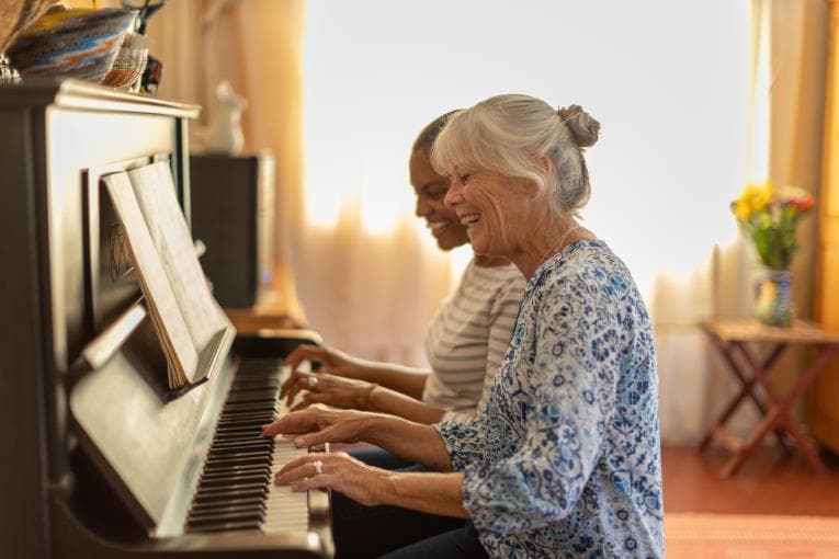 Two women playing the piano