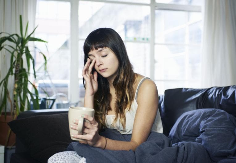 Woman sitting on couch exhausted