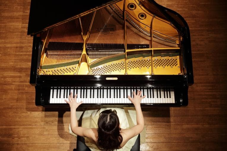 Woman playing piano in concert hall