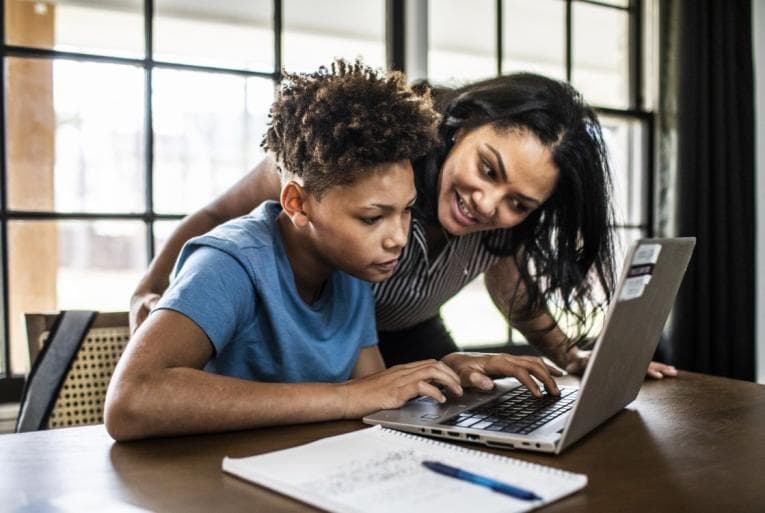 Caregiver giving homework help to teen