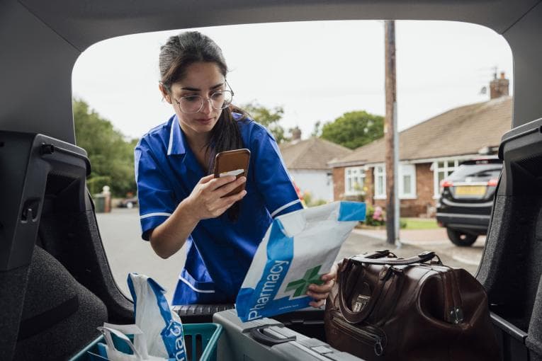 District nurse checking prescription in her car