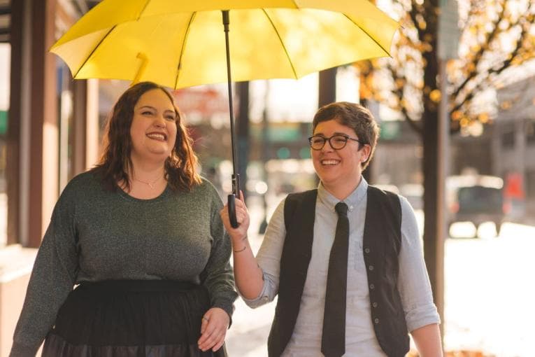 Couple under a yellow umbrella