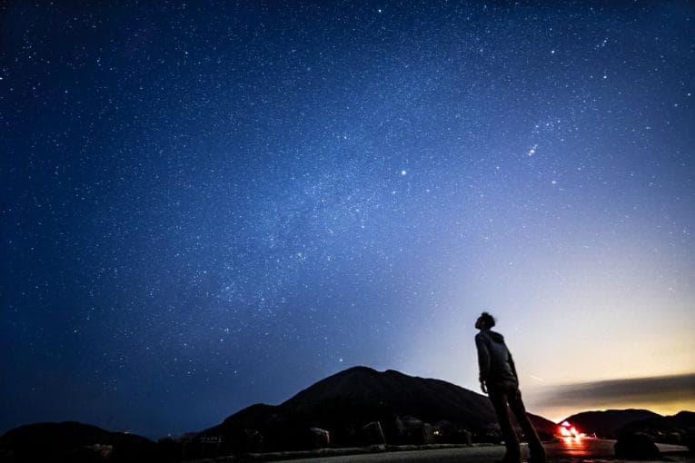 Person stargazing at a wide open sky