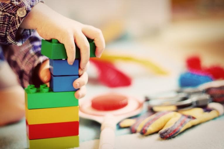 Child's hands playing with duplo bricks