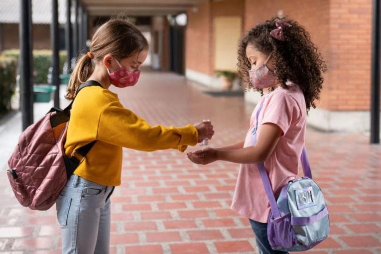 Kids using masks and sharing hand sanitiser