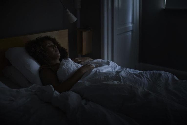 Person laying in a darkened bedroom