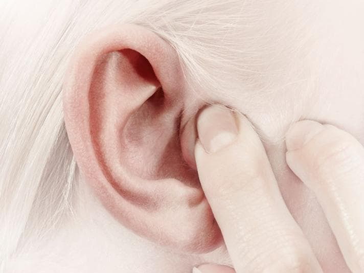 Closeup of person blocking their ear