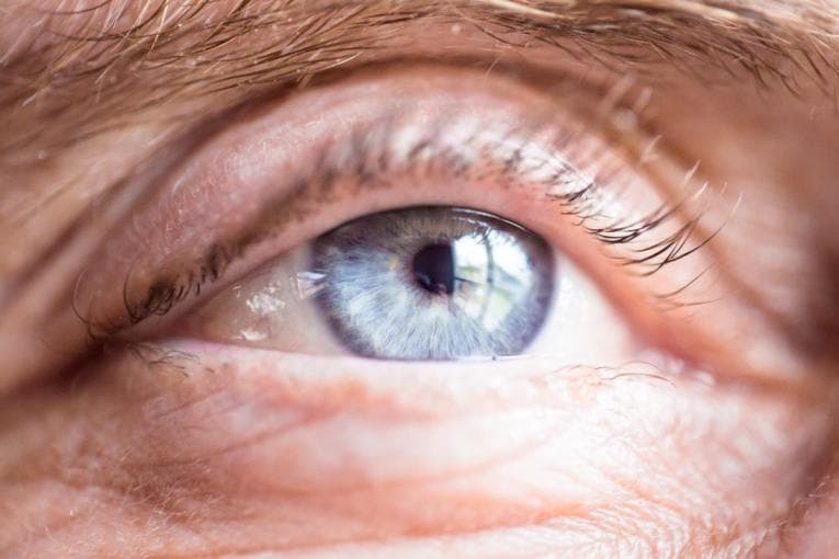 Close up of older person's blue eye gazing into the distance