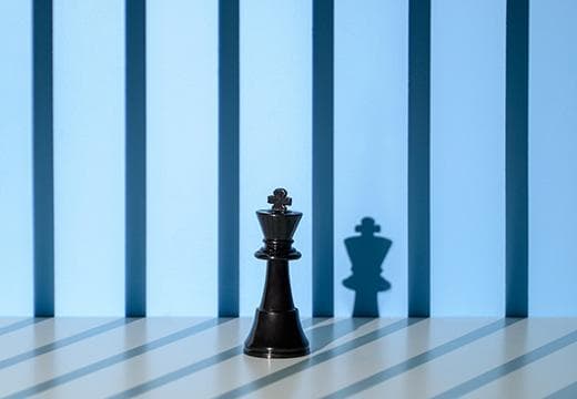 King chess piece with shadows of bars