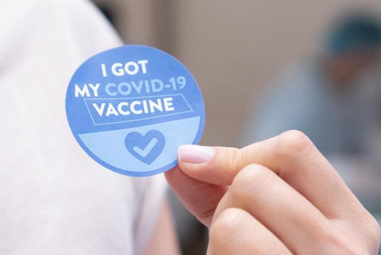 A blue sticker reading 'I got my Covid-19 vaccine'