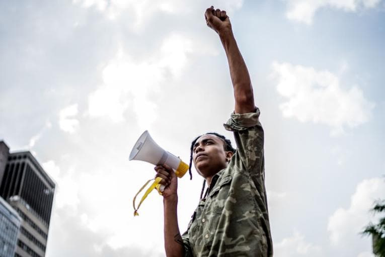 Person with megaphone and their fist in the air